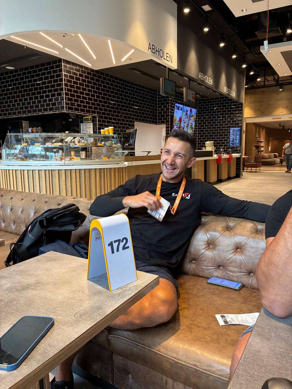 Mann sitzt lächelnd auf Couch im Café – Servix